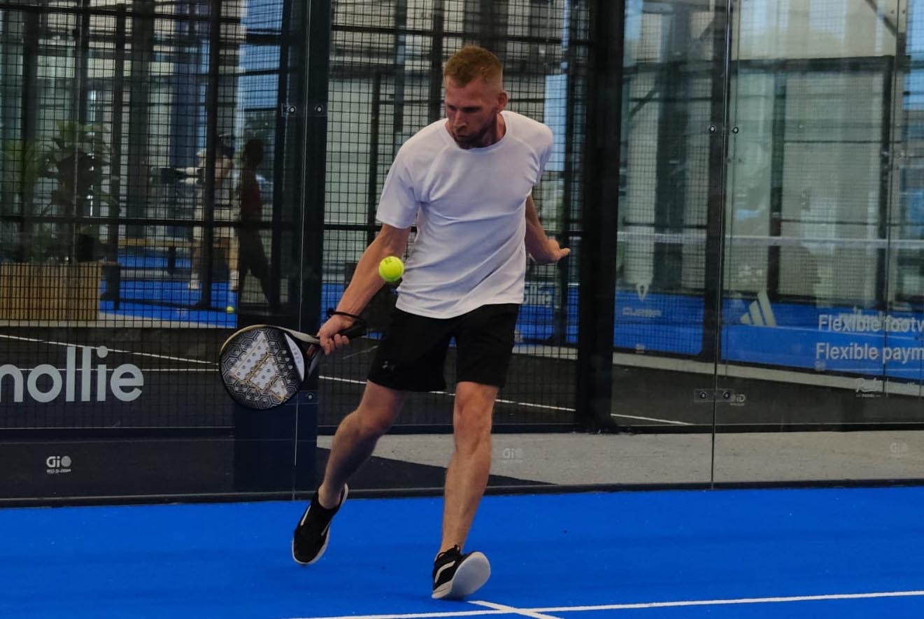 Een man speelt op het toernooi Padel voor Parkinson en slaat een bal